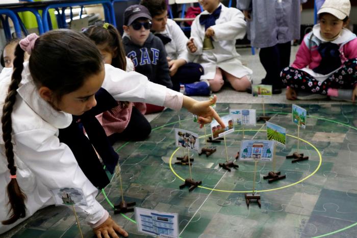 Niños armando el puzzle del los perímetros de protección de pozos