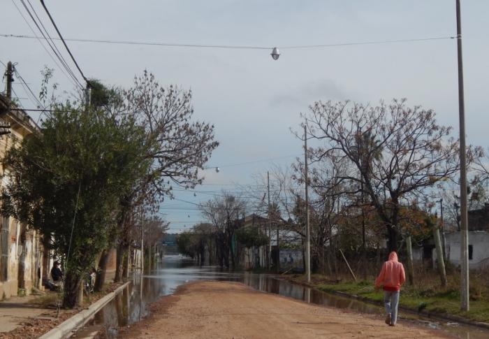 Calle casi inundada del Interior del país. Una persona en bicicleta