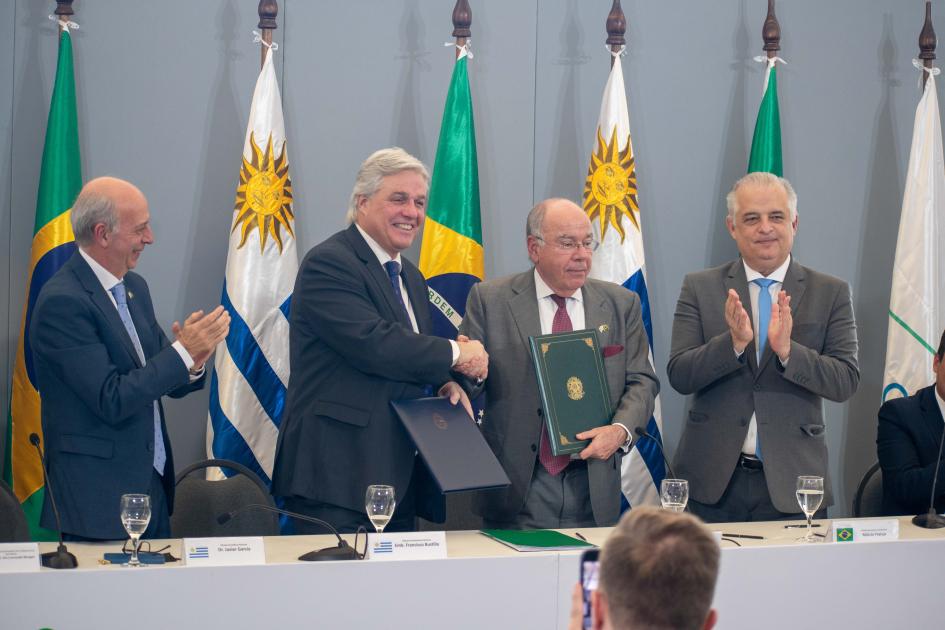 Autoridades de Uruguay y Brasil saludándose en mesa 