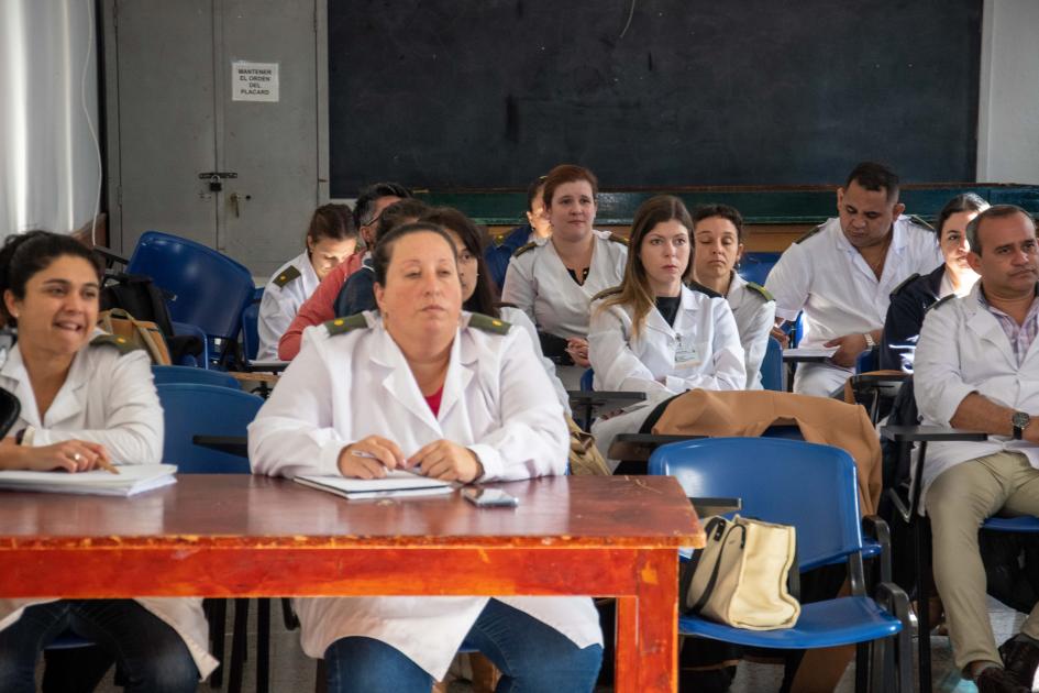 Funcionarios de Sanidad Militar sentados en clase recibiendo capacitación sobre Género