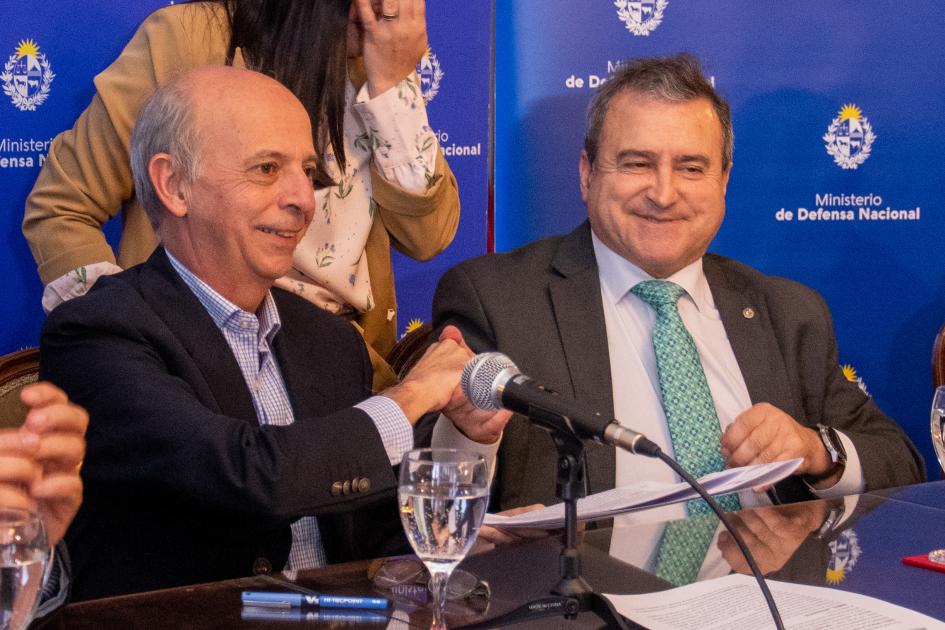 Ministro de Defensa Nacional junto a Ministro de Vivienda dándose la mano luego de la firma