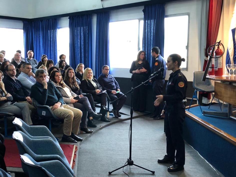 Capacitación sobre protección y defensa contra incendios Personal sentado escuchando a instructora del curso sobre protección contra incendios