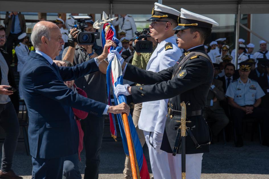 Ministro de Defensa Javier García entregando bandera de Artigas a alumno de la Escuela Naval