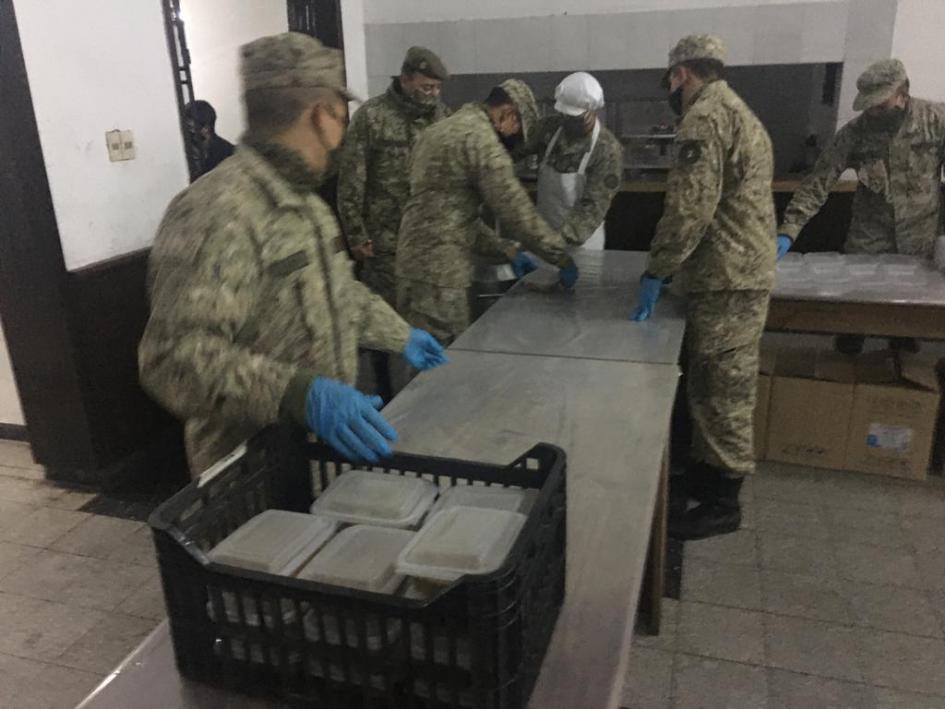 Personal militar preparando viandas de alimentos para entregar