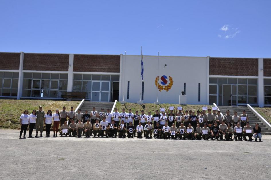 Grupo de estudiantes del Liceo Militar de Tacuarembó parados con carteles en las manos formando la frase Noviazgos Libres de Violencia
