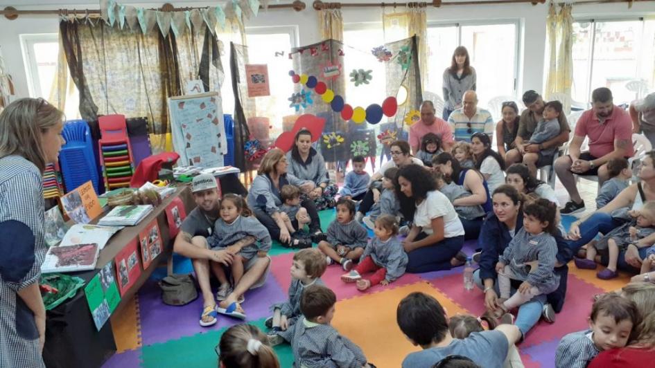 Maestra del jardín hablando con niños y padres Maestra del jardín hablando con niños y padres en un salón