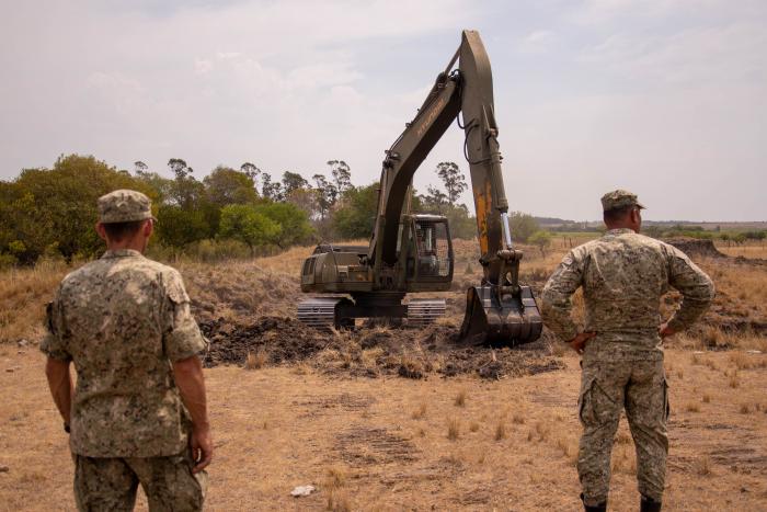 Máquina retroexcavadora realizando limpieza de tajamares Máquina retroexcavadora realizando limpieza de tajamares