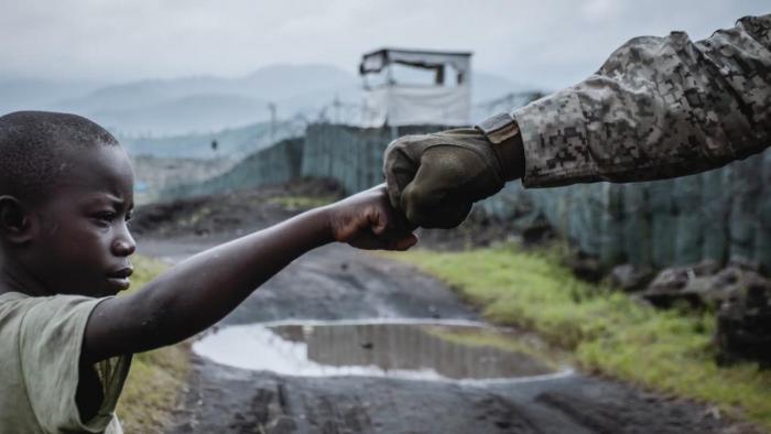 Niño congoleño chocando el puño con un militar uruguayo