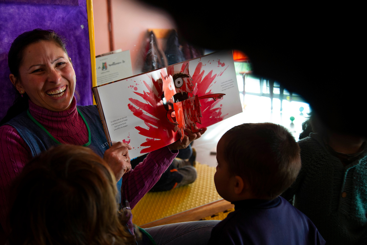 Mujer muestra libro niños
