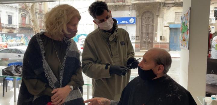 Fernanda Auersperg junto a usuario de refugio y peluquero en refugio Hotel Urban