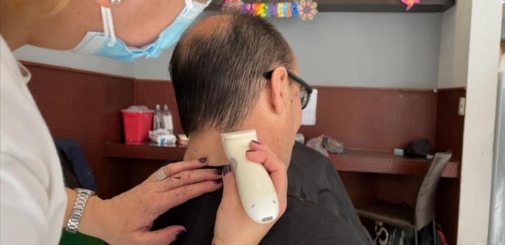 Peluquera corta cabello a un usuario de refugio en primera jornada solidaria