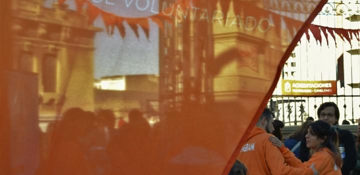 Bandera con texto que dice primer foro de voluntariado, delante de los participantes de la actividad