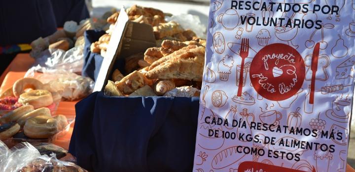 Bandeja con bizcochos y al lado un cartel que dice "alimentos rescatados por voluntarios, proyecto plato lleno".