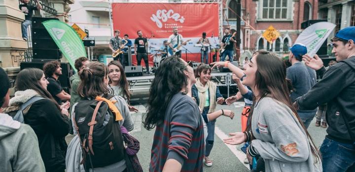 Mujeres cantando en primer plano y de fondo, una banda tocando sobre el escenario de Yesca.