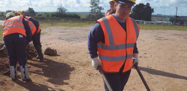 Trabajadora lleva una carretilla repleta de tierra Trabajadora lleva una carretilla repleta de tierra