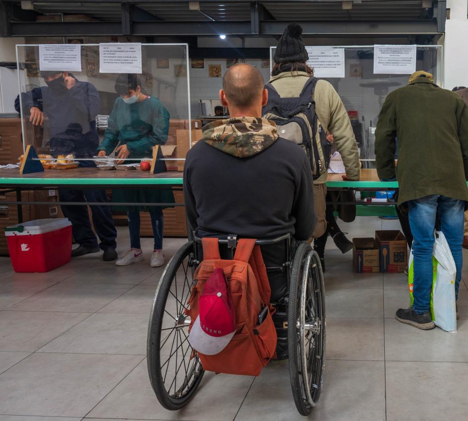 Comedor de INDA. Persona en silla de ruedas espera su turno.