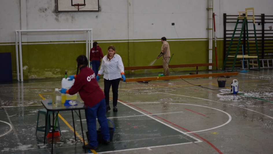 Limpieza de plaza nº2 que dejó de funcionar como centro de evacuados Personas limpiando la plaza de deportes nº2