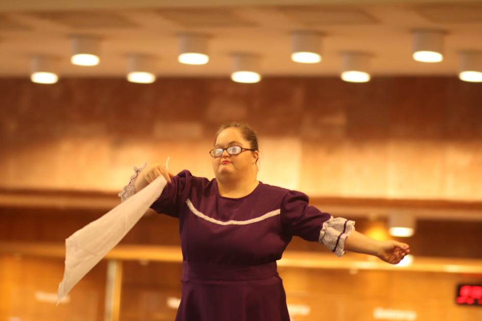 Mujer baila Pericón Nacional, revolea pañuelo blanco con su mano derecha.