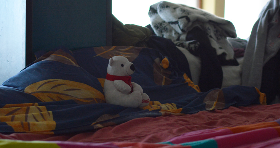 Un oso de peluche sobre una cama, posiblemente en un centro de evacuados Un oso de peluche sobre una cama