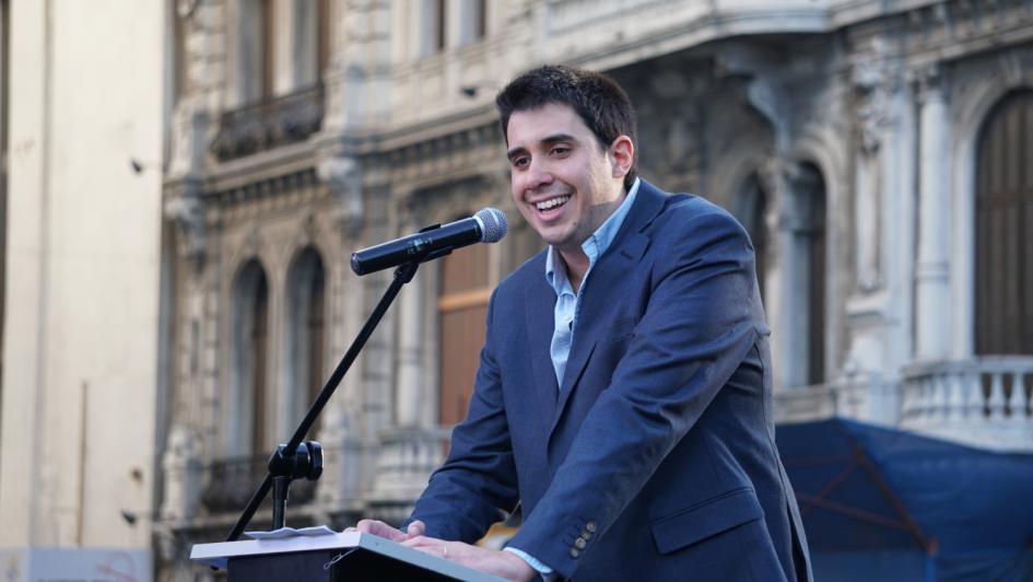 Felipe Paullier en el estrado durante su oratoria, al fondo edificios de la Plaza del Entrevero