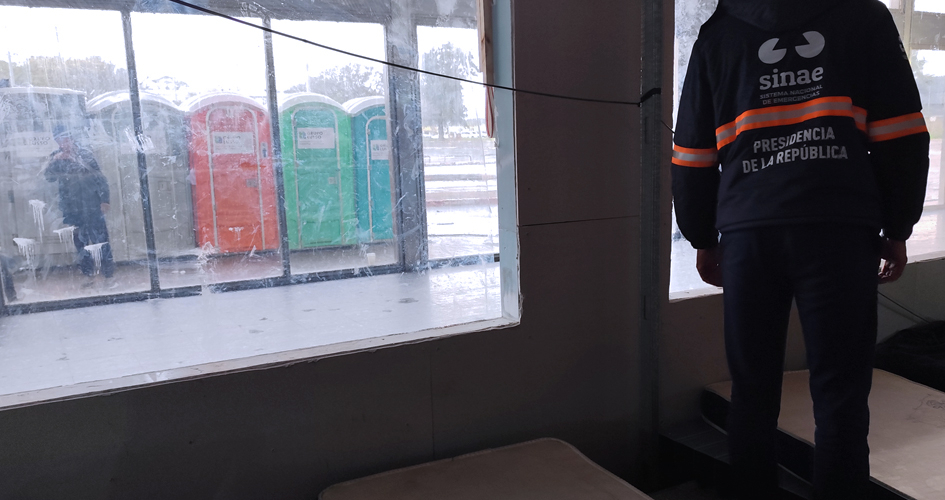 Persona con uniforme de Sinae parado frente a una ventana