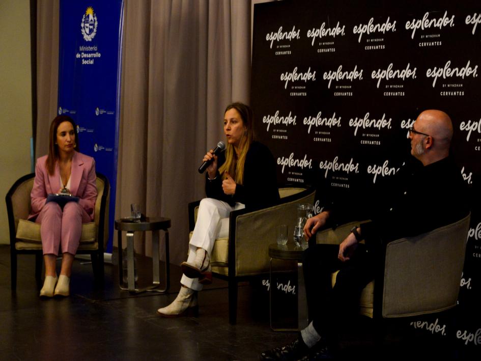 Cecilia Sena durante su disertación. Foto: Presidencia de la República Tres expositores sentados en butacas sobre escenario: Milman, Sena y Brum. Atrás banner del hotel.