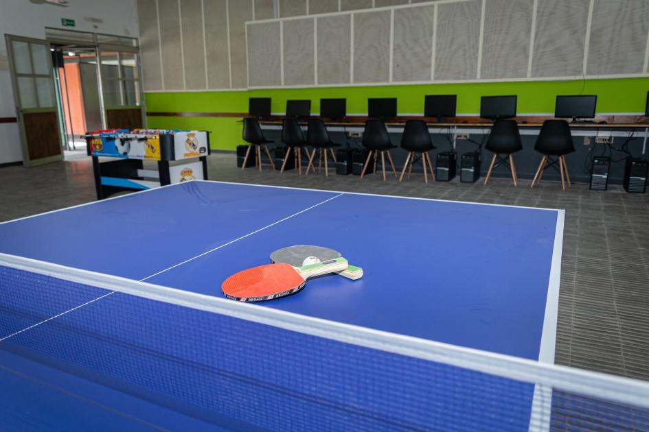 Mesa de ping pong, futbolito y computadoras en sala de esparcimiento 