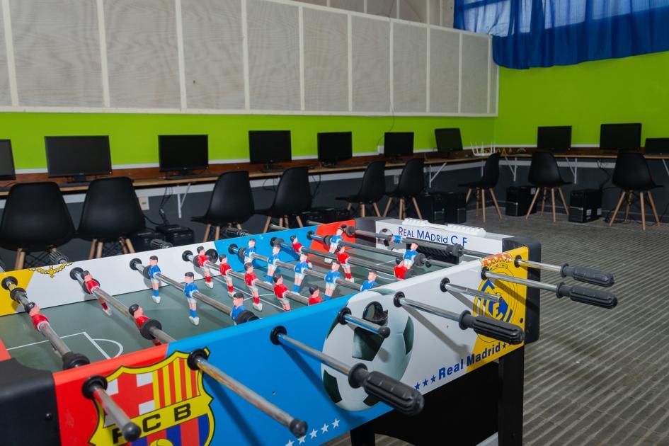 Sala de juegos con futbolito y computadoras para seguimiento educativo