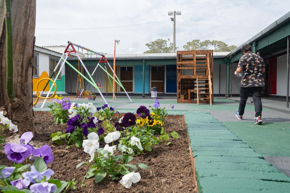 Patio amplio con flores, juegos en madera, hamacas y tobogán fabricados por la DINALI