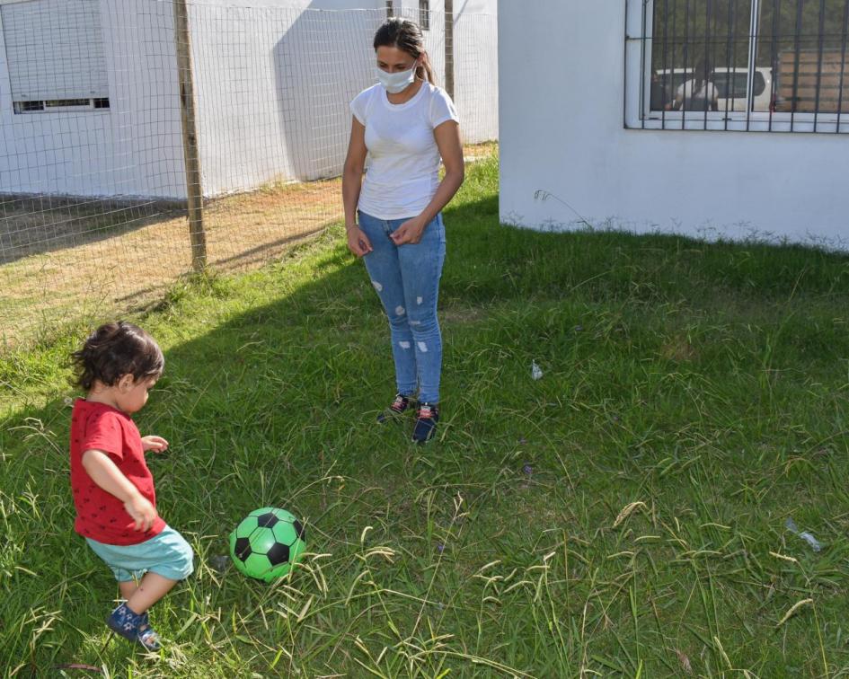 Ana Karen y su hijo instalados en la nueva casa Niño pequeño juega fútbol en patio
