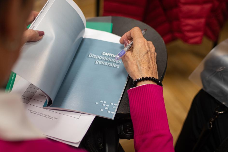 Manos de persona abriendo el librillo de la ley 19580