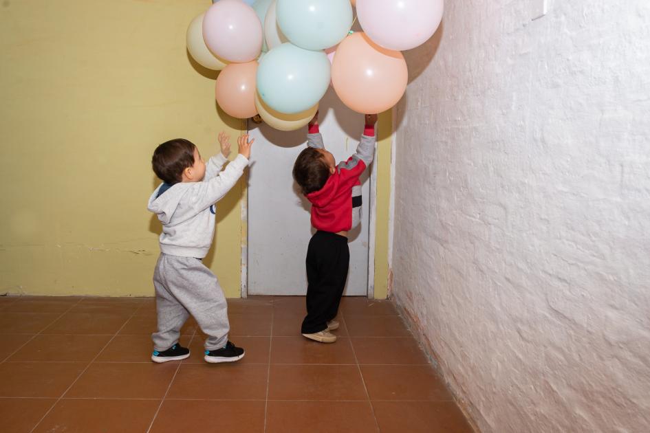 Dos niños pequeños juegan con globos de colores