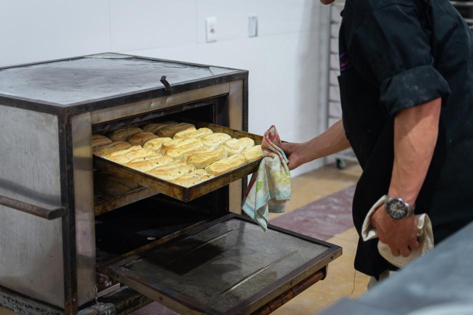 Participante del curso sacando panes del horno 