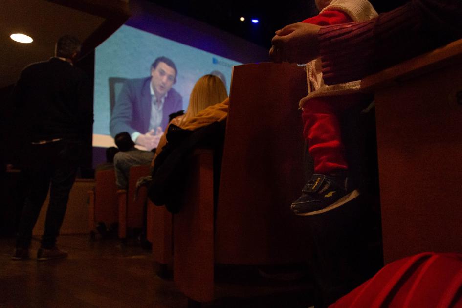 Asistentes al evento viendo el video de presentación 