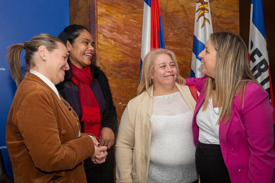 Andrea Brugman y Cecilia Sena junto a emprendedoras de Florida y Rivera. Brugman y Sena junto a emprendedoras de Rivera y Florida. De pie junto a pabellones nacionales.