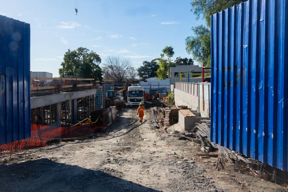 Portón azul de metal abierto al predio donde se construye el hospital del Cerro y oficina Mides