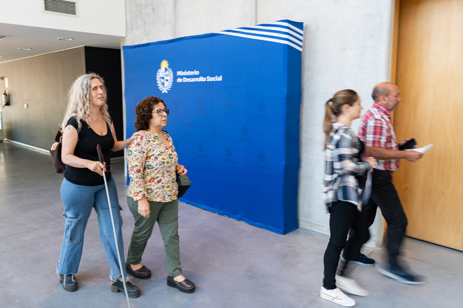 Cuatro personas ingresan a la sala donde se desarrolló la actividad de presentación