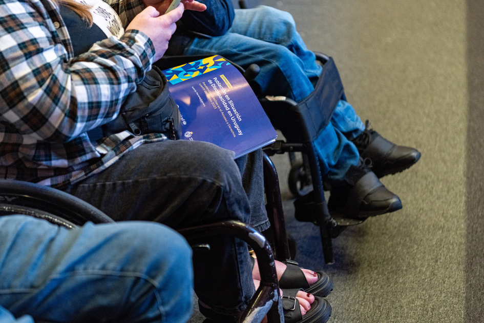 Toma de publicación impresa sobre las piernas de una persona en silla de ruedas