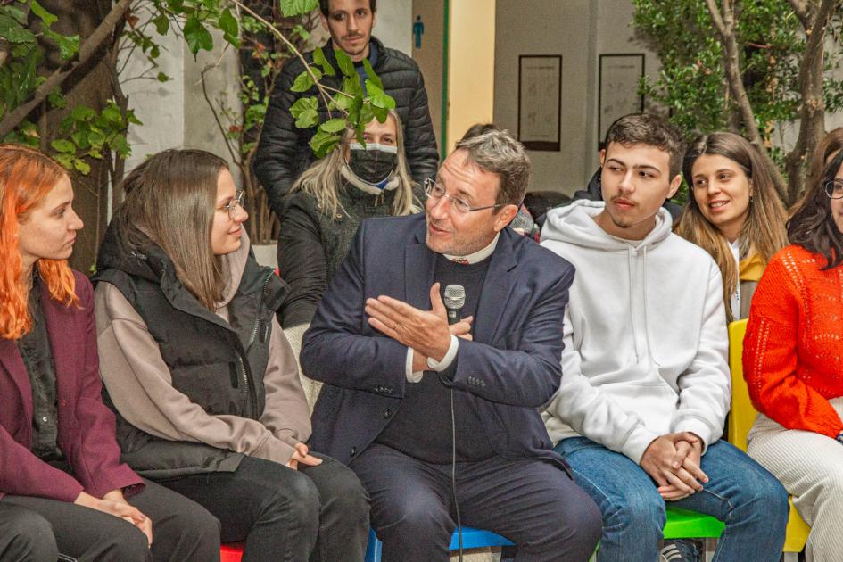 Hombre representante de Naciones Unidas le hace preguntas a alumnos egresados del Instituto Ánima