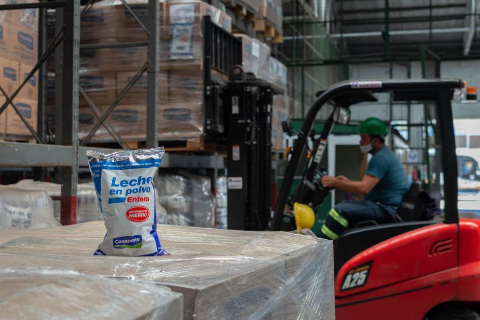 Imagen de los productos donados en el centro logístico de INDA. Panorámica de las cajas de la donación, junto a operario.