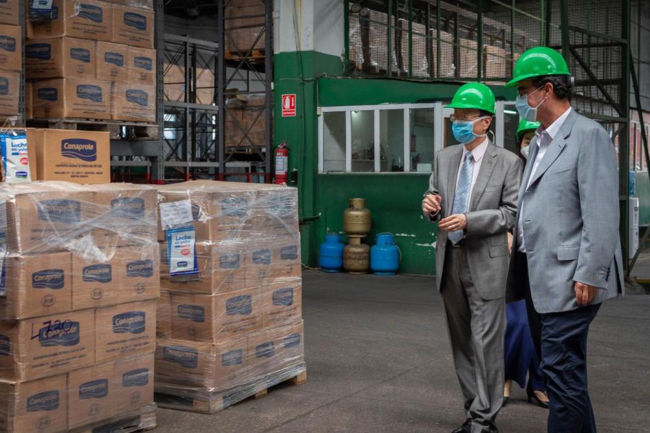 Donación de leche en polvo al INDA. Autoridades caminando por el centro logístico.