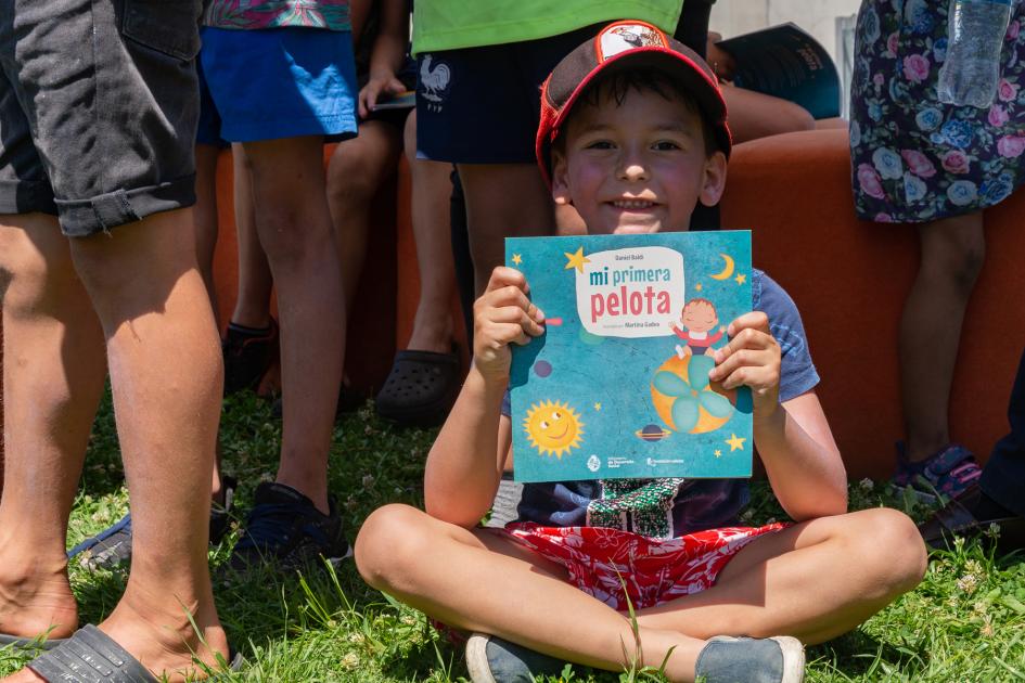 Daniel Baldi junto a integrantes del Club de Niños Los Tejanitos y el Centro CAIF Los Suritos Niño muestra el libro "Mi primera Pelota" de Daniel Baldi