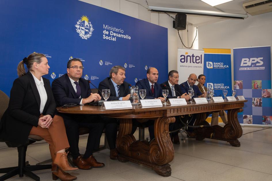 Mesa de oradores con presencia de jerarcas hombres y mujeres de MIDES, ANTEL, BROU, BPS y AGESIC