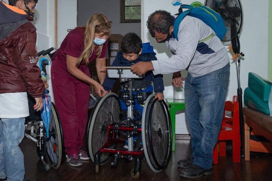 Equipo técnico y familia de niño usuario de silla de ruedas usuario en el CENATT