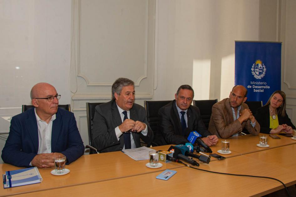 Conrado Ferber, presidente del INAC, durante su presentación. Mesa de autoridades y oradores. Al Fondo banner institucional del MIDES.
