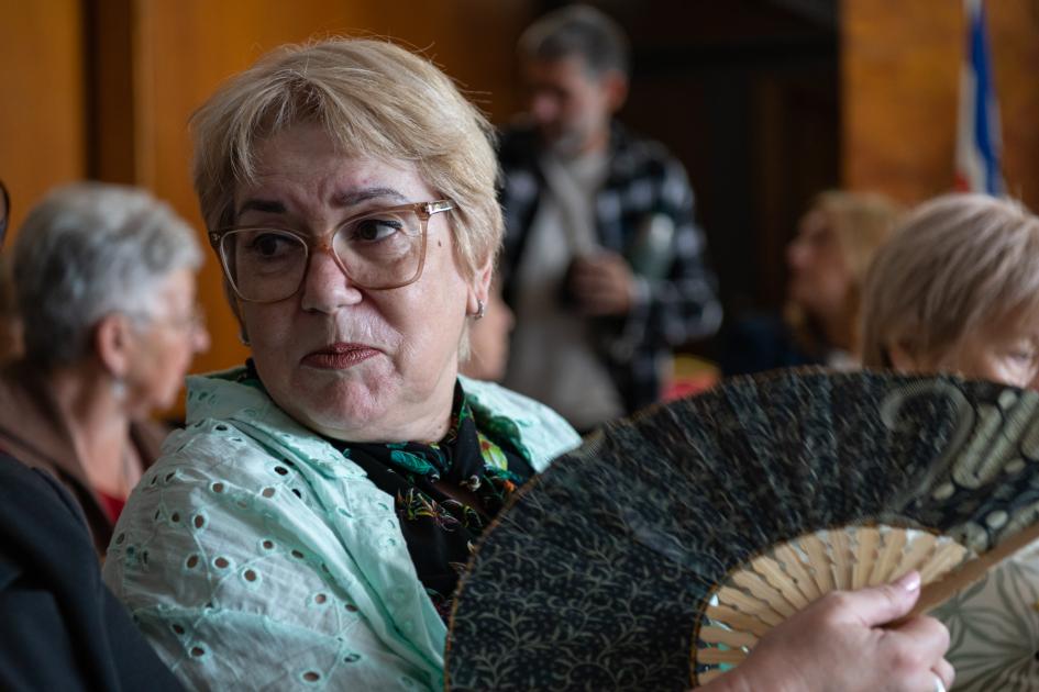Asistente al Consejo Consultivo de Personas Mayores. Público formado por personas mayores, primer plano de señora con abanico abierto.