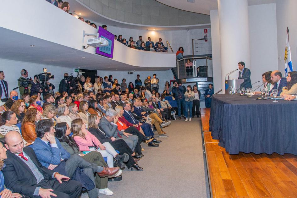 Platea de autoridades, técnicos y público en general frente a mesa de oradores