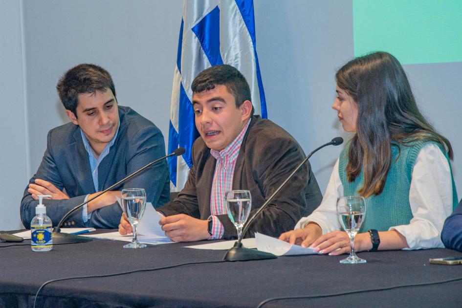 Felipe Paullier junto a jóvenes representantes del CAC INAU en mesa de oradores