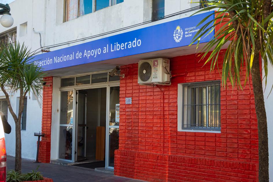 Fachada del centro DINALI donde funcionan los talleres Fachada de ladrillos color rojo brillante, ventana y puerta de vidrio, cartel de Mides/DINALI