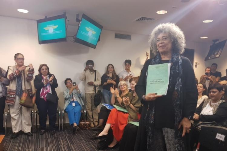 Angela Davis muestra un ejemplar impreso del Plan Nacional de Equidad Racial y Afrodescendencia